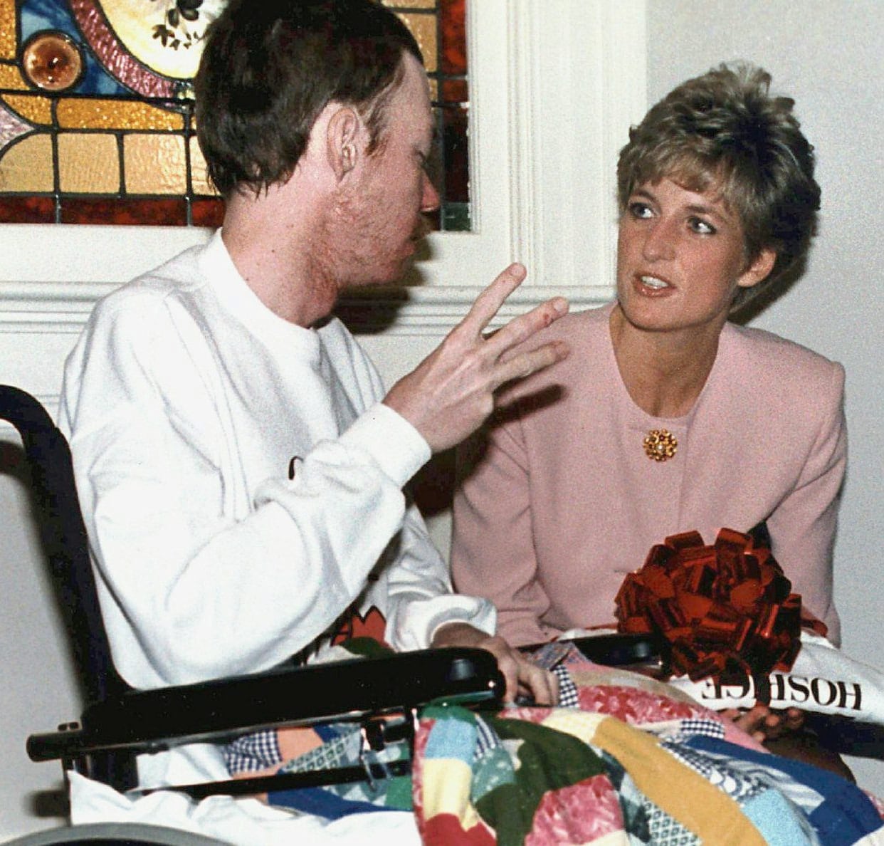 A man in a wheelchair talks to a woman. 