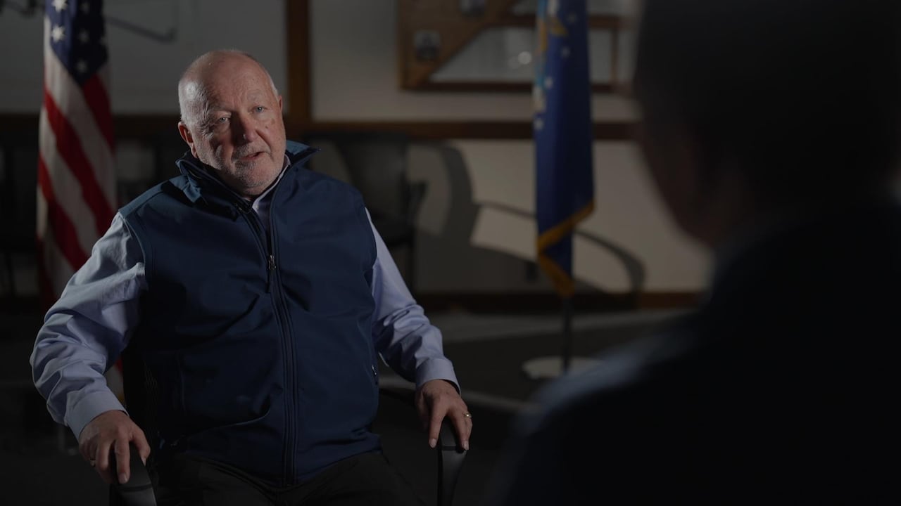 A person is seen seated during an interview.