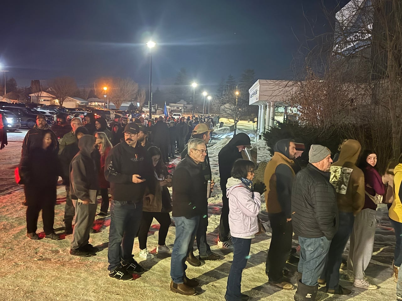 People lined up in front of a building in winter.