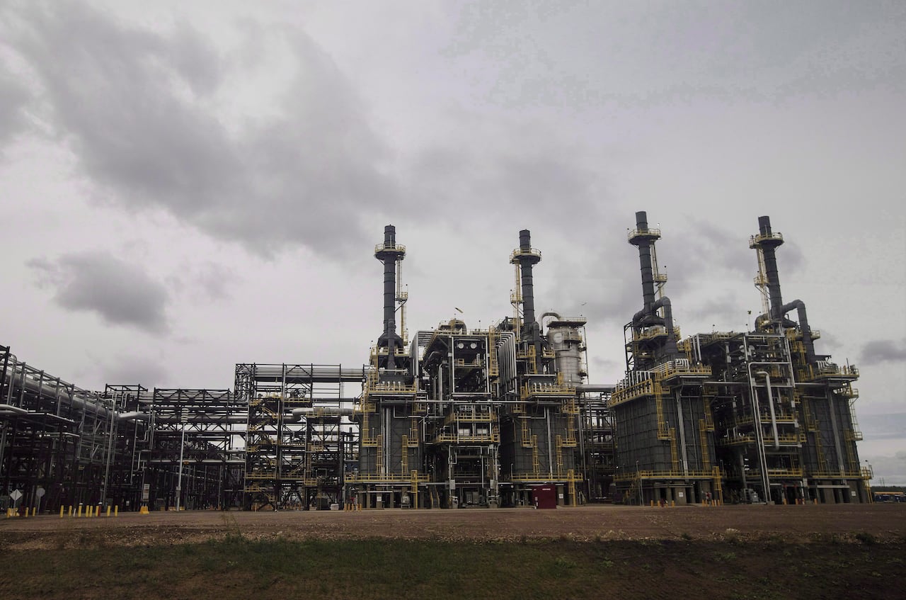 The spires of an crude processing unit are seen against the sky.